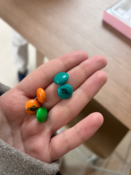 Close-up of candies in a palm, with turtles depicted on some candy, serving as an example input for vision-language capabilities.